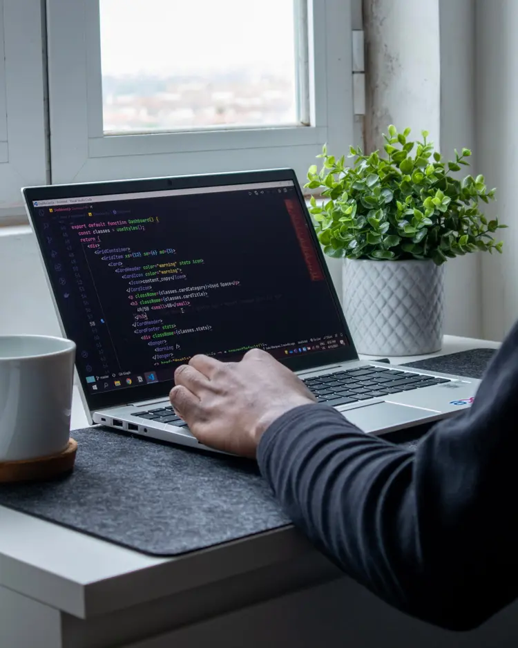 Mão humana digitando no teclado de um notebook